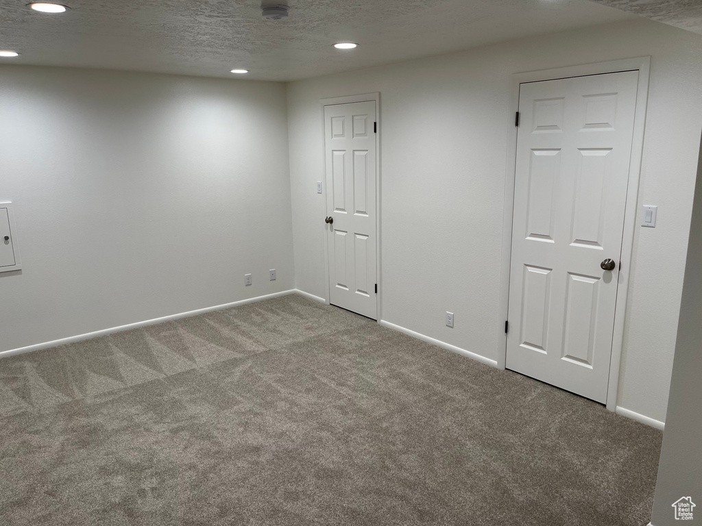 Empty room featuring baseboards, recessed lighting, carpet flooring, and a textured ceiling