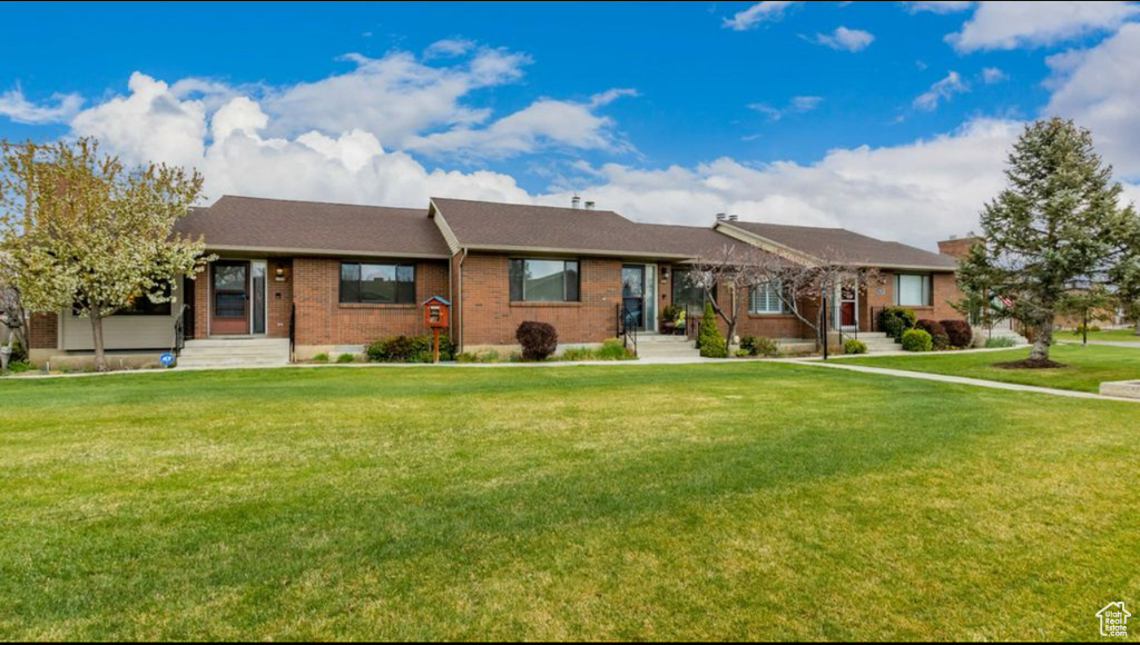 Ranch-style house featuring a front lawn and brick siding