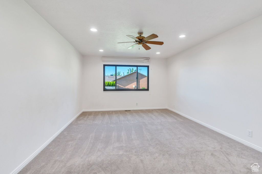 Carpeted empty room with ceiling fan and recessed lighting
