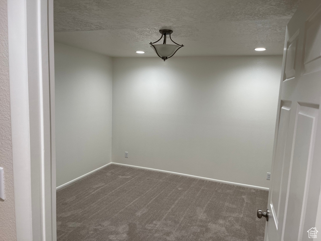 Empty room featuring baseboards, recessed lighting, carpet flooring, and a textured ceiling