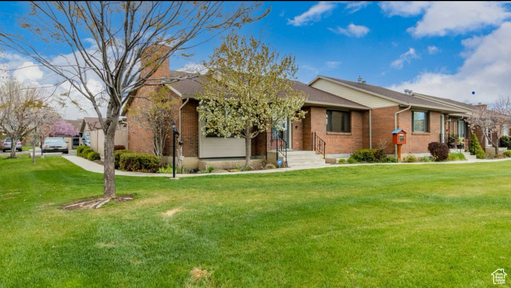 Ranch-style home with brick siding and a front yard