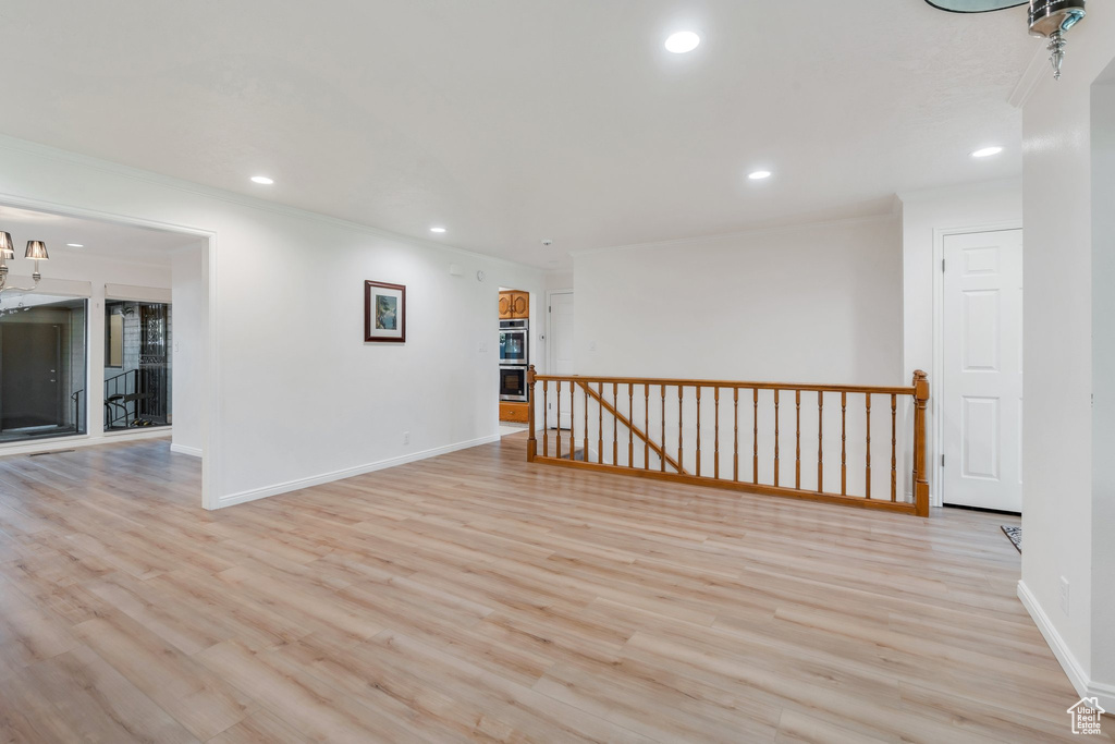 Empty room with recessed lighting, light wood-type flooring, and a chandelier