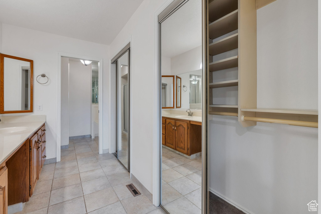 Full bath with two vanities and tile patterned flooring