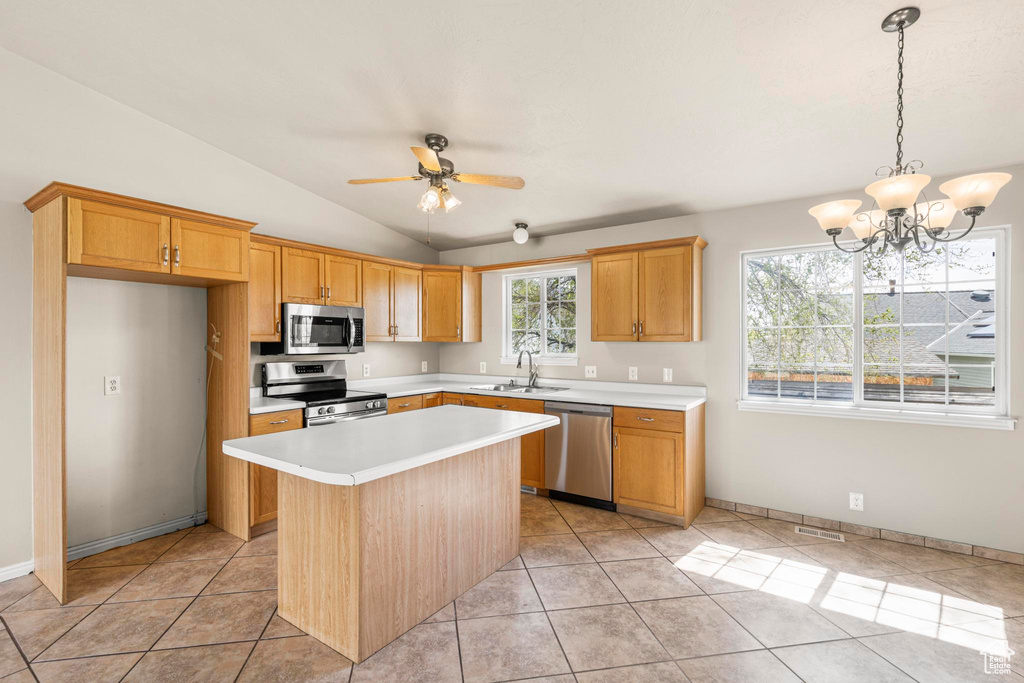 Kitchen featuring light countertops, a sink, vaulted ceiling, and stainless steel appliances