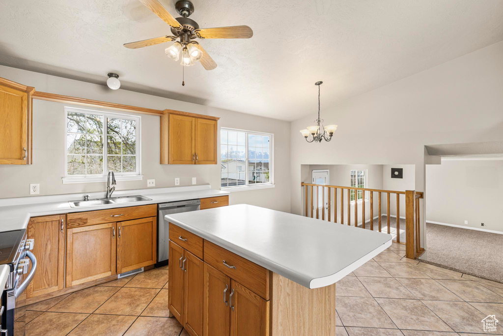 Kitchen with ceiling fan with notable chandelier, light tile patterned flooring, light countertops, a sink, and stainless steel appliances