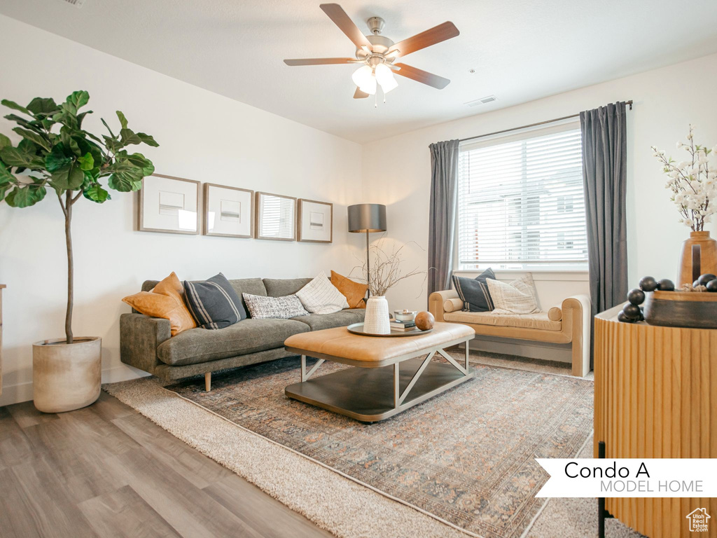 Living room with wood finished floors, a ceiling fan, and visible vents