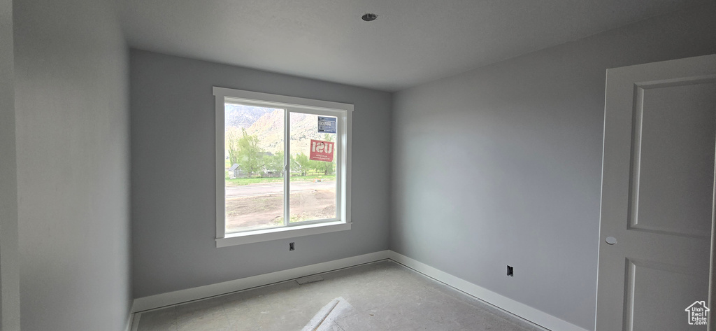 Spare room featuring a wealth of natural light and baseboards