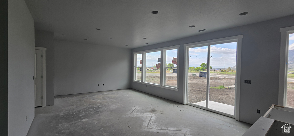 Unfurnished room with concrete floors and a wealth of natural light
