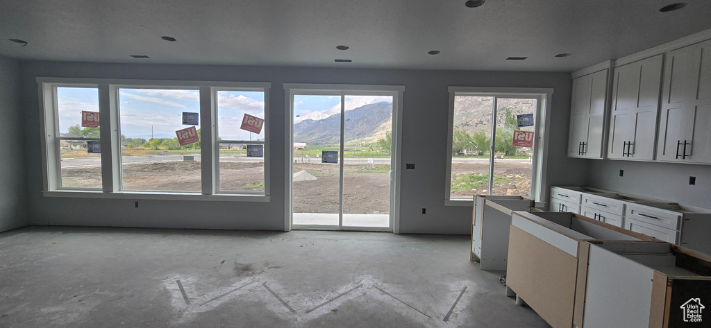 Entryway featuring a wealth of natural light, concrete floors, and a mountain view