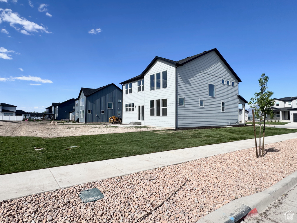 View of property exterior with a lawn and a residential view