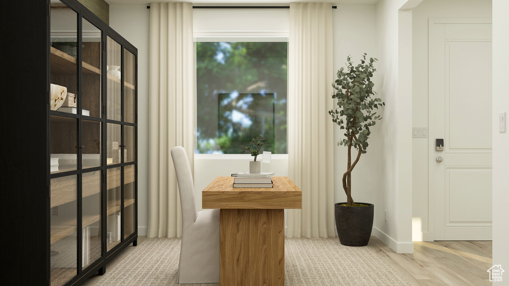 Doorway to outside with light wood-style floors and baseboards