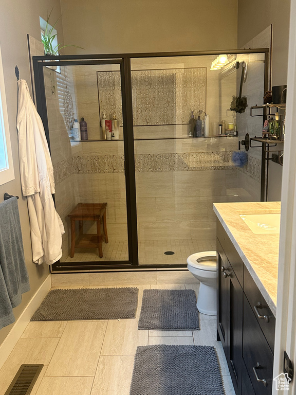 Full bath featuring toilet, vanity, visible vents, and a stall shower