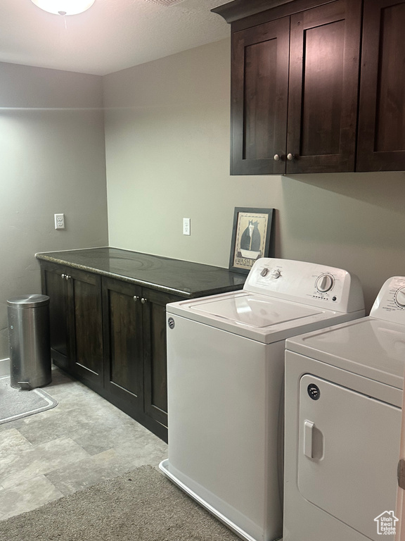 Washroom featuring cabinet space and washer and dryer
