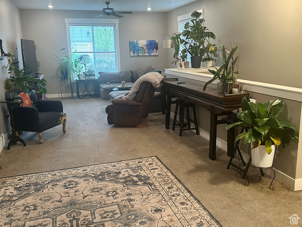 Sitting room featuring ceiling fan, carpet floors, and baseboards