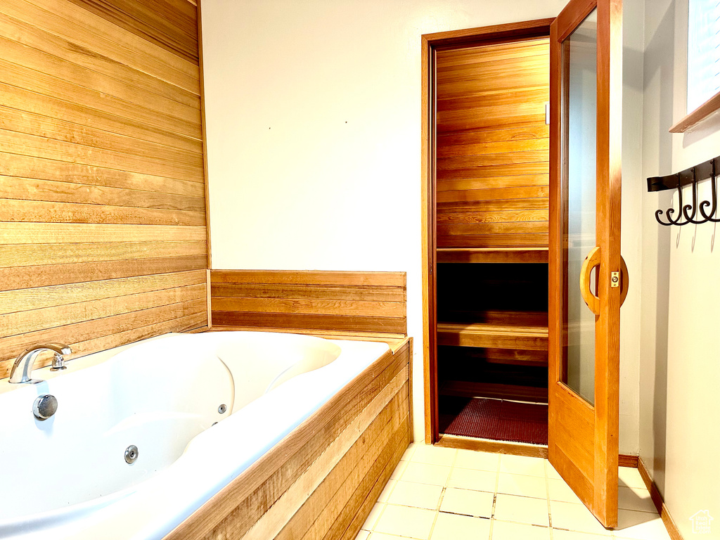 Bathroom with a tub with jets and tile patterned flooring