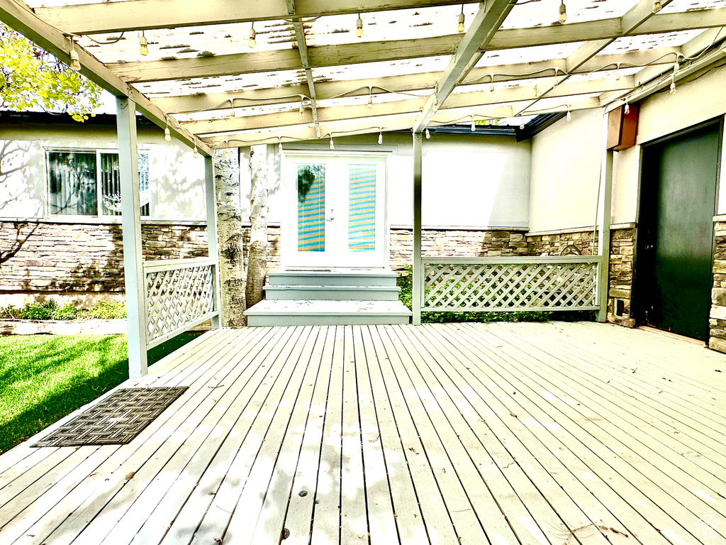 Wooden terrace featuring french doors and a pergola