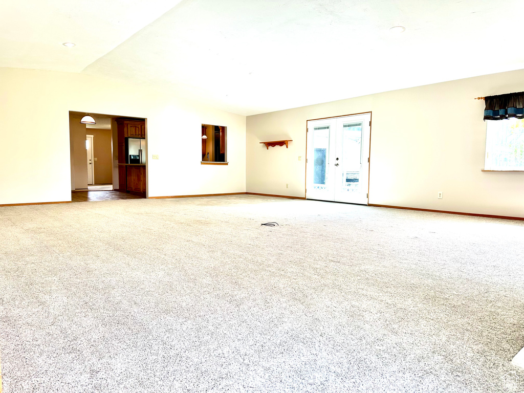 Unfurnished living room featuring light colored carpet and baseboards