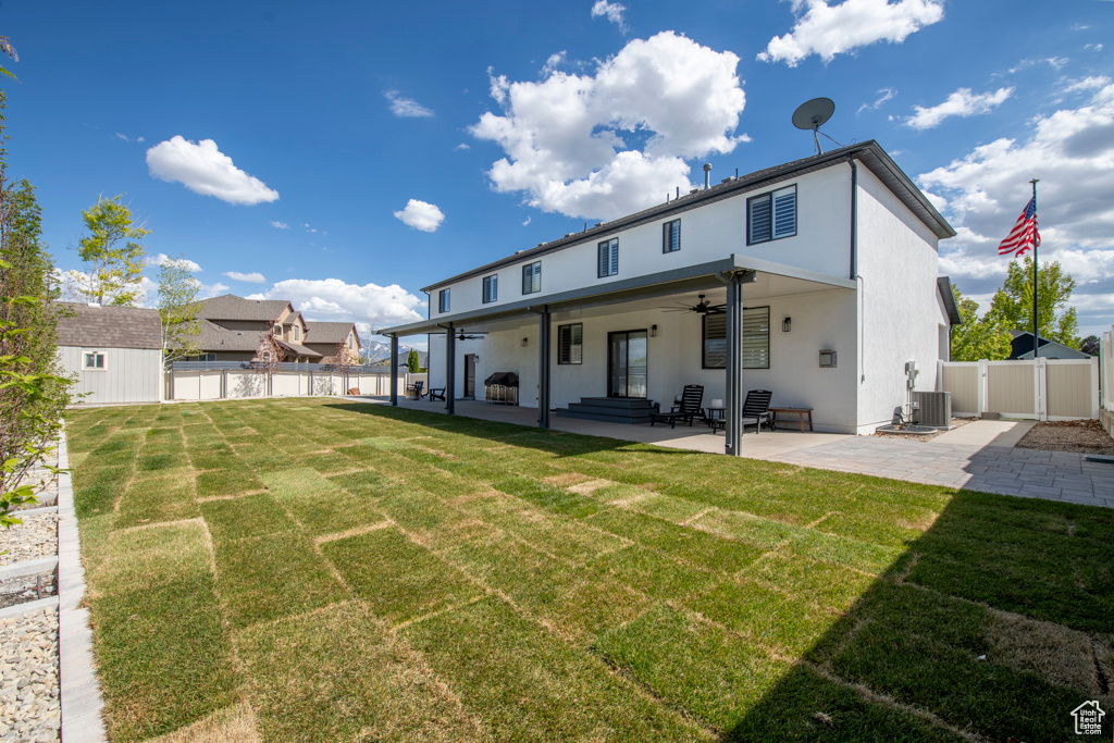 Back of property featuring a fenced backyard, a ceiling fan, a patio, and a lawn