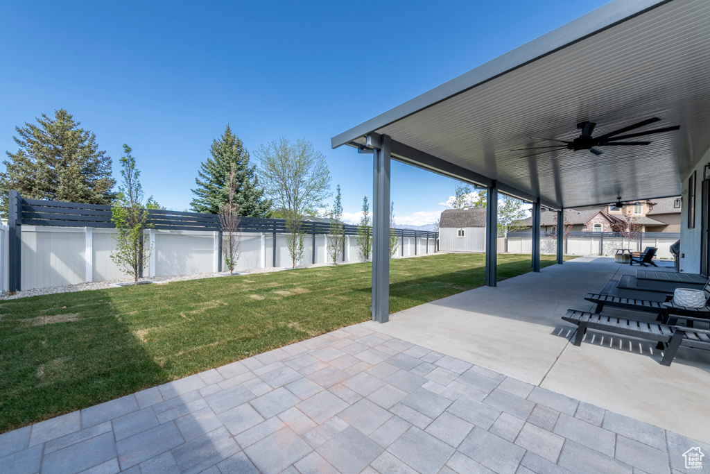 View of patio / terrace with a water view, ceiling fan, and a fenced backyard
