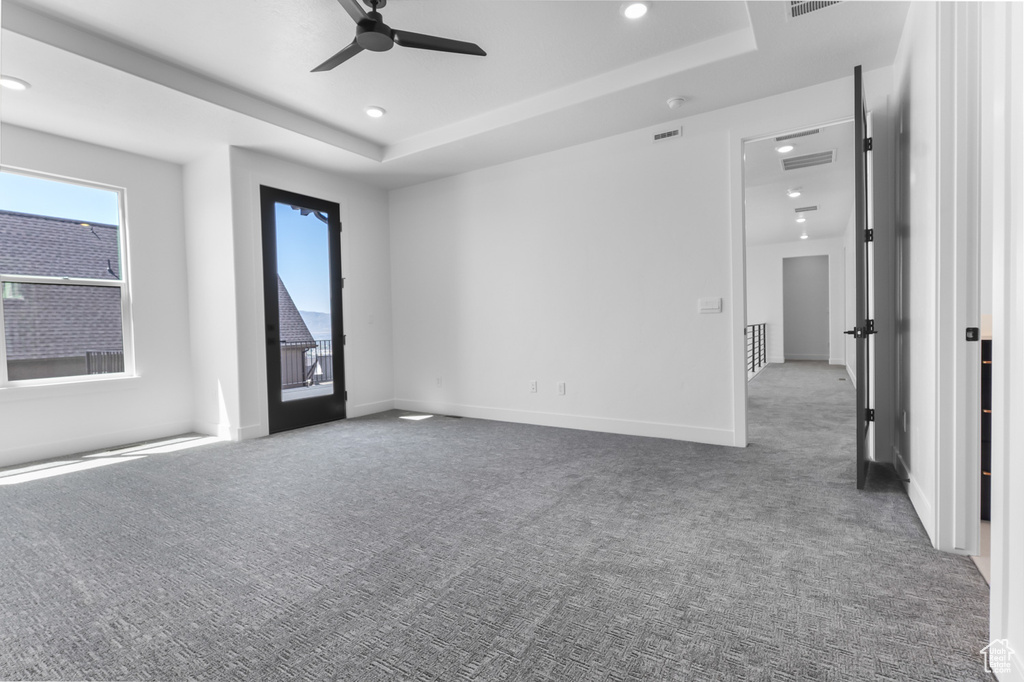 Unfurnished room featuring carpet flooring, a ceiling fan, a raised ceiling, recessed lighting, and baseboards