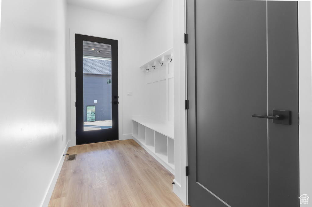 Mudroom with light wood-style flooring and baseboards