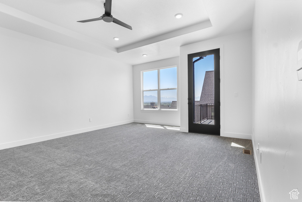 Unfurnished room with carpet floors, ceiling fan, recessed lighting, baseboards, and a raised ceiling