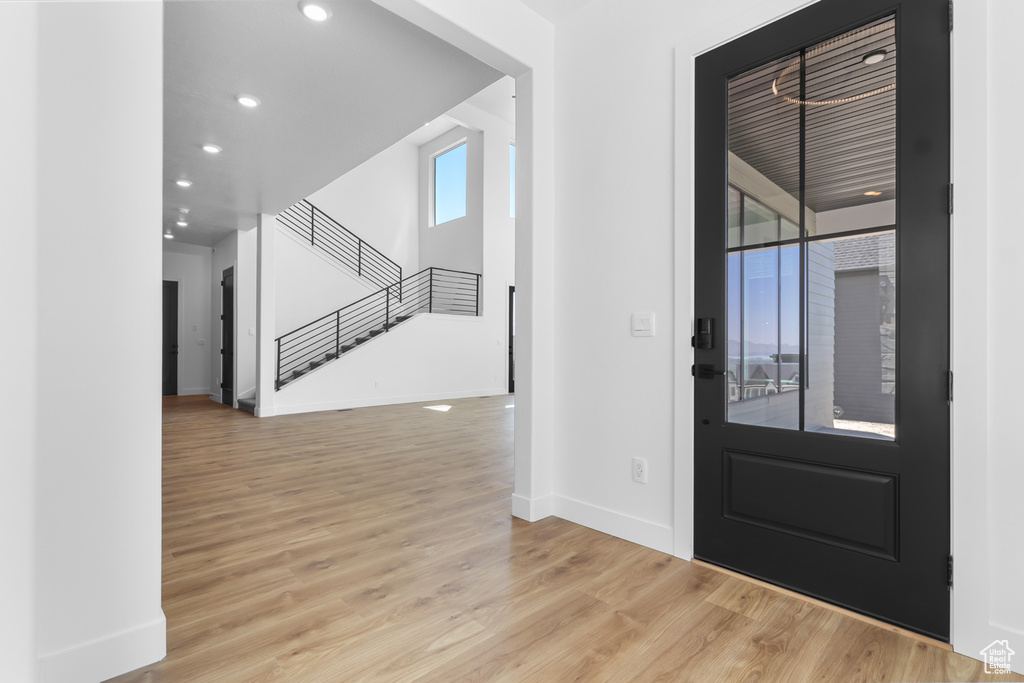 Foyer entrance featuring stairs, baseboards, wood finished floors, and recessed lighting