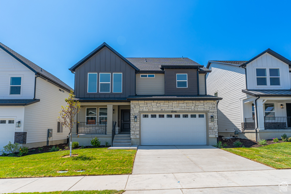 Craftsman-style house with a porch, board and batten siding, concrete driveway, a front yard, and a garage