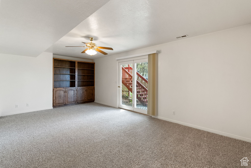Empty room with light carpet, a ceiling fan, and visible vents