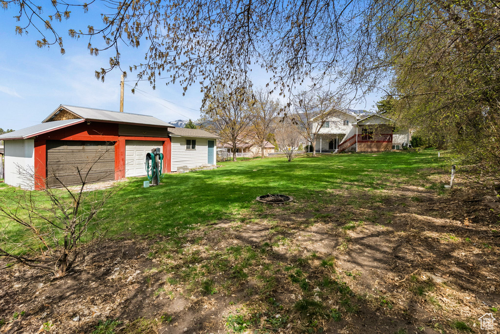 View of yard featuring a garage and an outbuilding