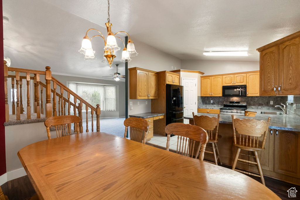 Dining space featuring stairway, baseboards, and ceiling fan with notable chandelier