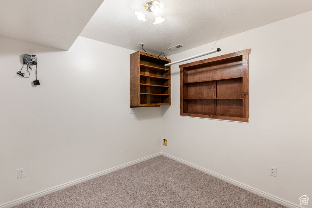 Spare room featuring baseboards, visible vents, and carpet floors