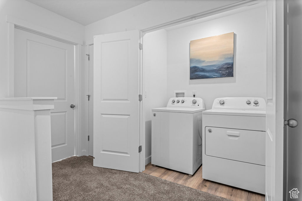 Laundry area with light carpet, independent washer and dryer, and laundry area
