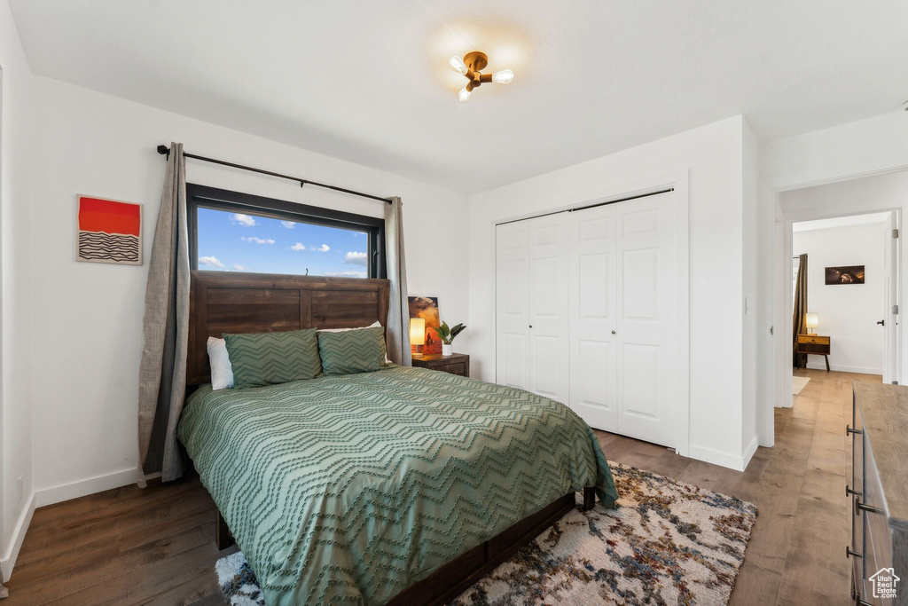 Bedroom featuring wood finished floors, baseboards, and a closet