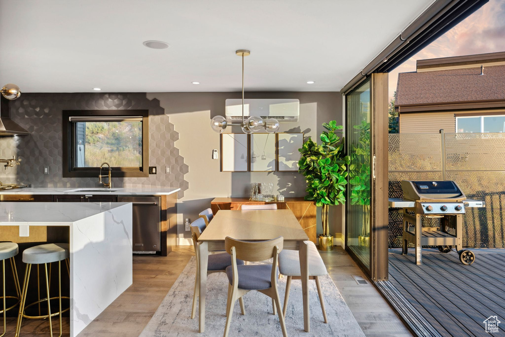 Dining area with recessed lighting, a chandelier, light wood-style floors, and a wall unit AC