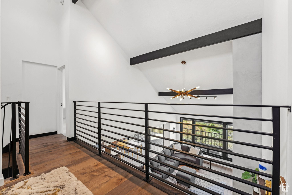 Interior space featuring beam ceiling, high vaulted ceiling, an inviting chandelier, and wood finished floors