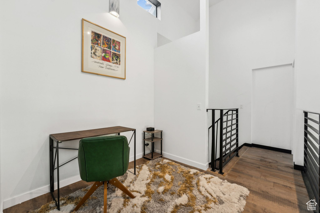 Stairs with baseboards, a high ceiling, and wood finished floors