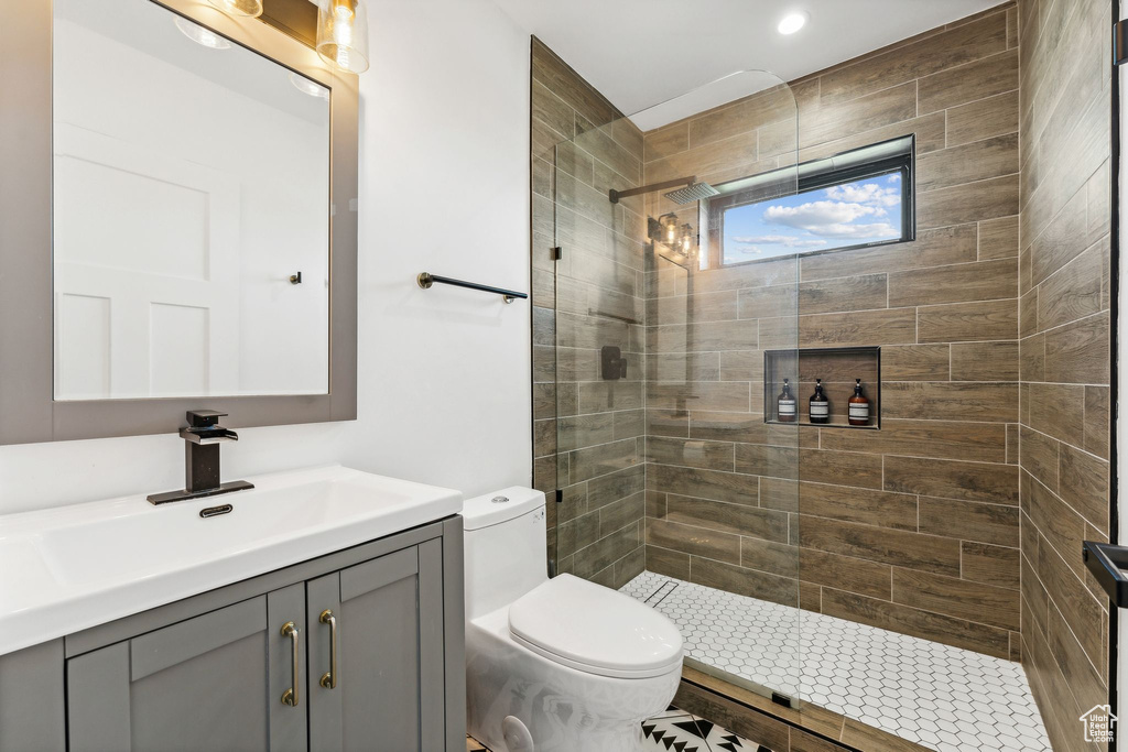 Bathroom with toilet, a walk in shower, and vanity