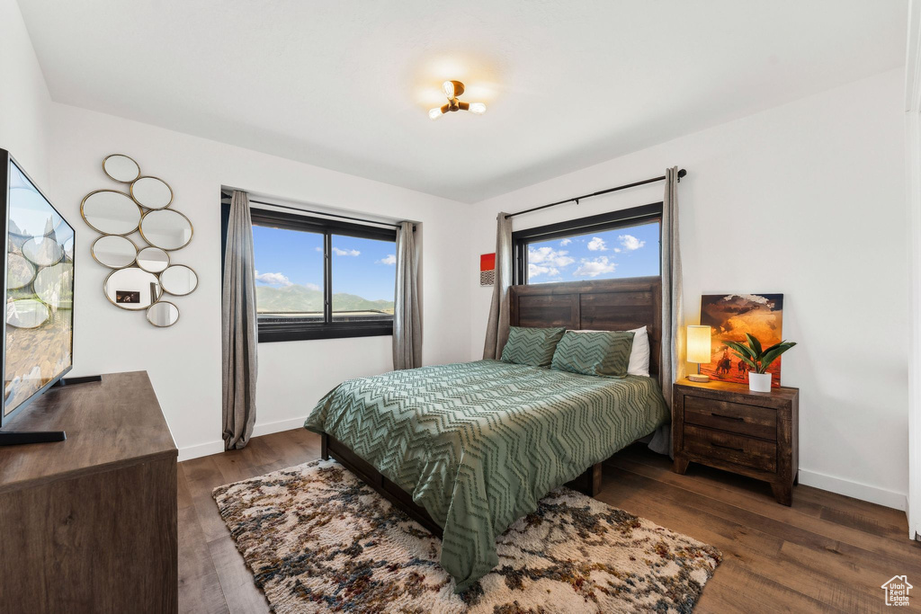Bedroom featuring dark wood-type flooring and baseboards