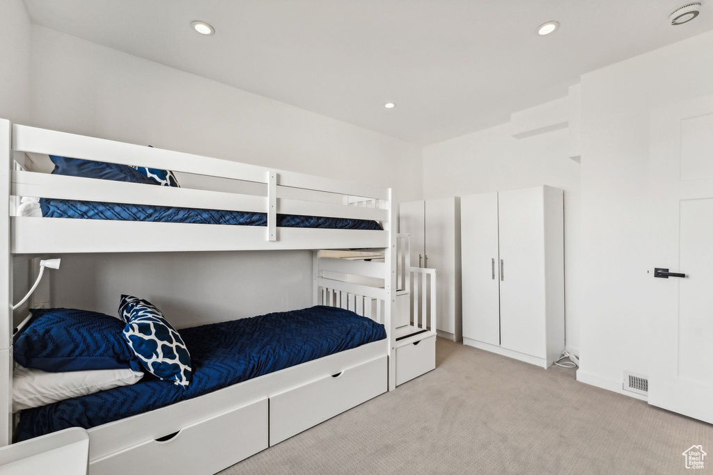 Bedroom featuring light carpet, recessed lighting, and visible vents