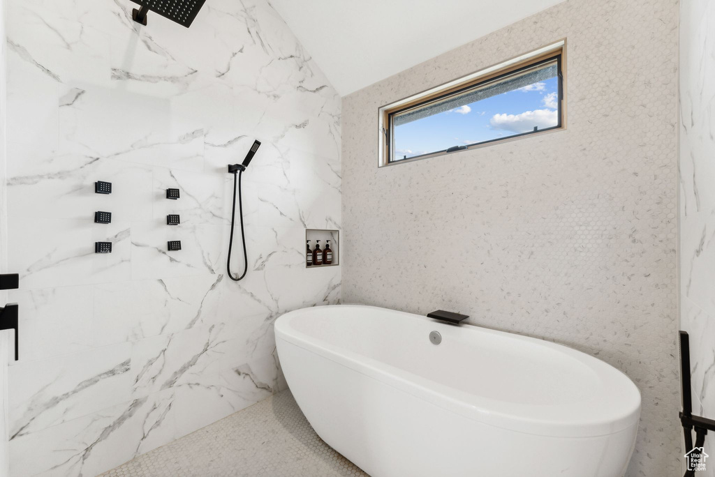 Bathroom with a freestanding bath and a marble finish shower