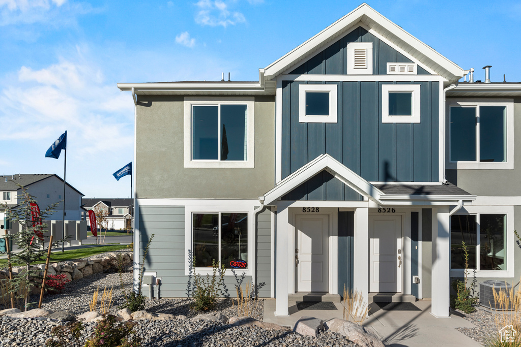 View of front facade with cooling unit and board and batten siding