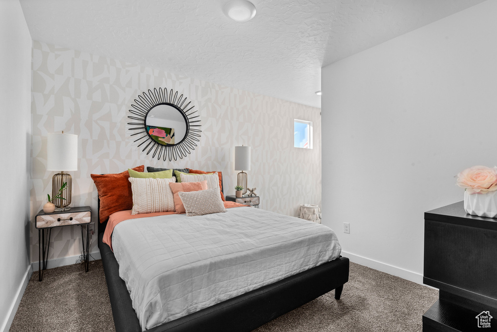 Bedroom with baseboards, wallpapered walls, and carpet floors