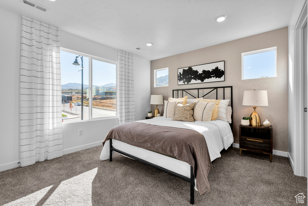 Carpeted bedroom featuring a mountain view, baseboards, visible vents, and recessed lighting