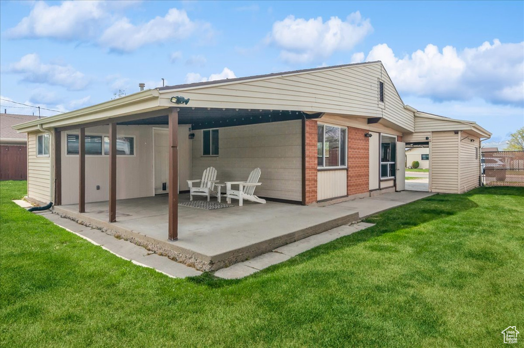 Rear view of house with a patio and a yard
