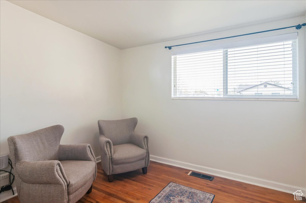 Living area featuring wood finished floors, baseboards, and visible vents
