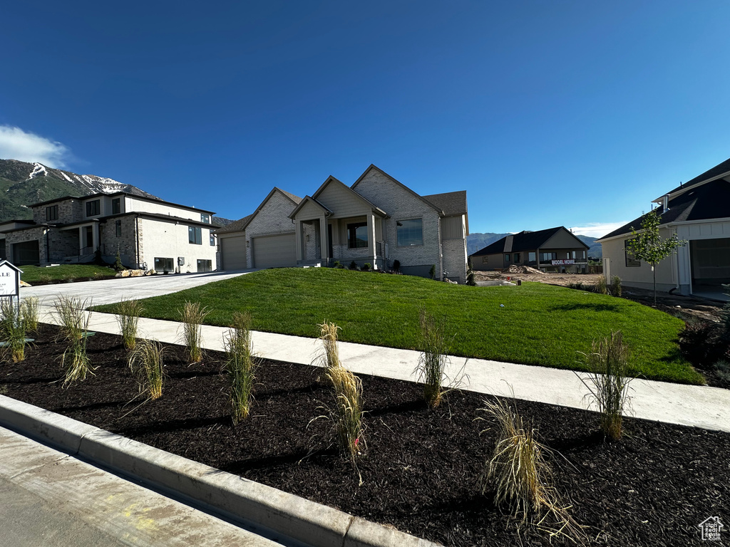 View of front of house with concrete driveway, a front lawn, a residential view, and an attached garage