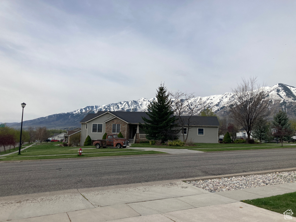 View of front of house with a mountain view and a front yard