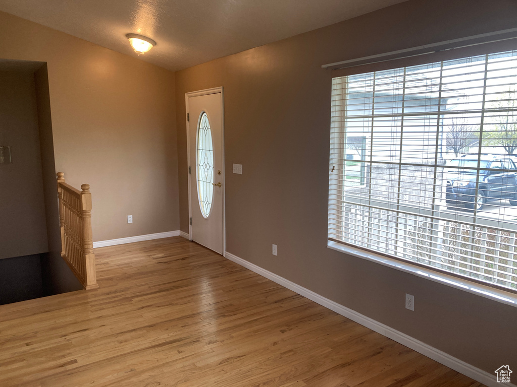Entrance foyer with baseboards and wood finished floors
