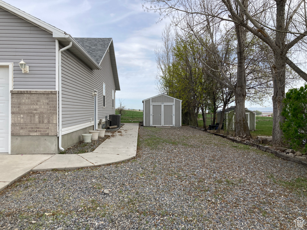 View of yard with an outbuilding, central AC, and a storage unit